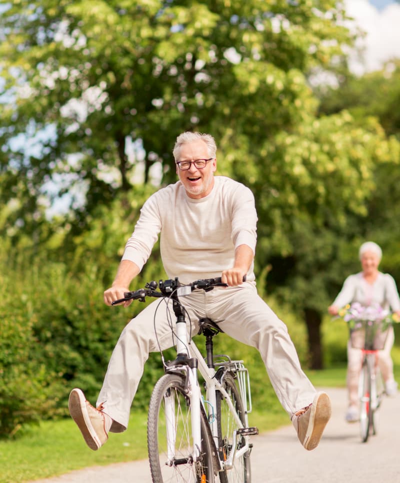 Happy old couple having fun riding a bike